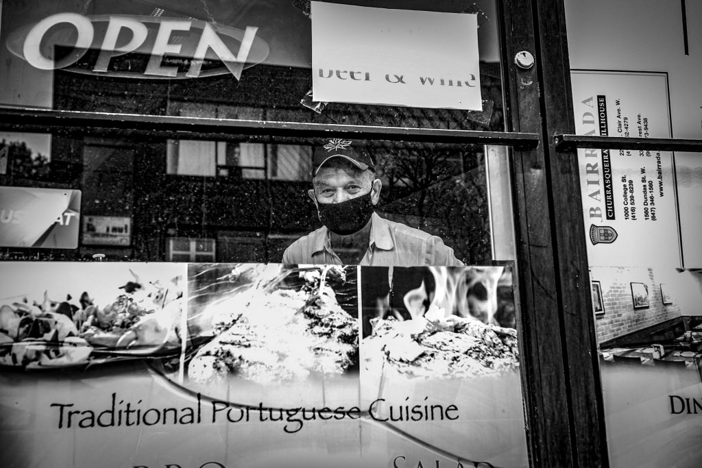 restaurant owner in window in Toronto by George Pimentel