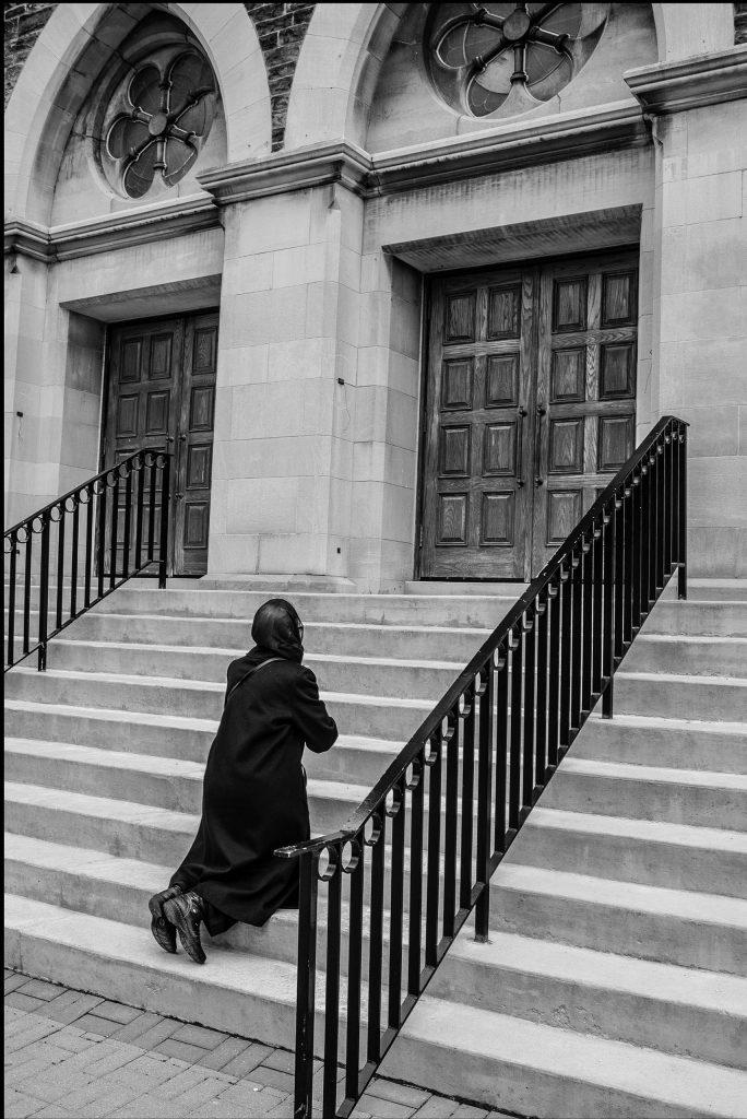 woman kneeling at church in Toronto by George Pimentel