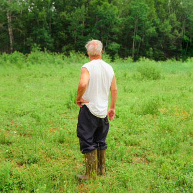 Portrait of man standing in grass. PEI