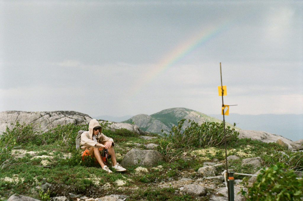man and rainbow in Quebec mountains